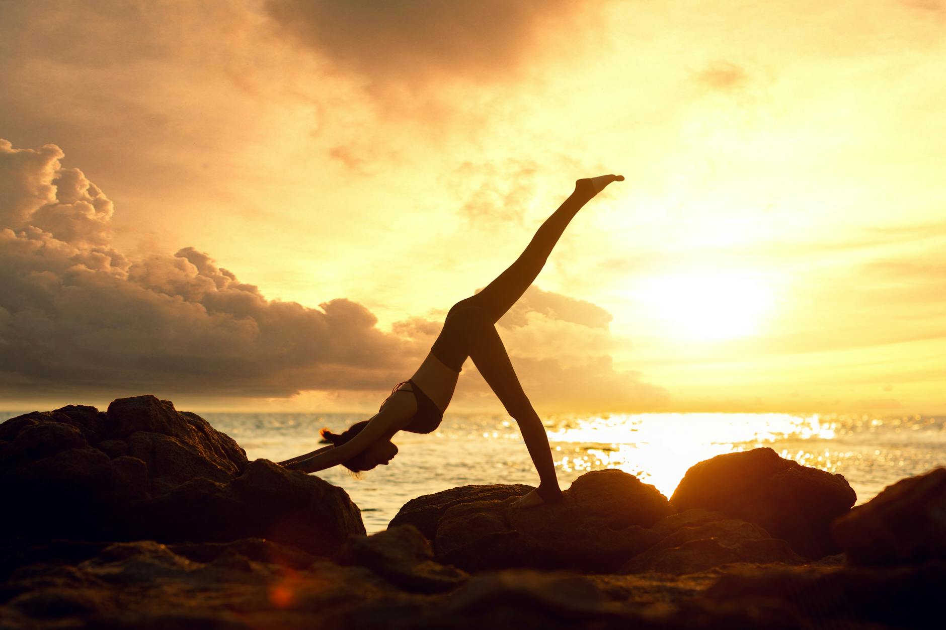 a woman doing yoga on the rocks